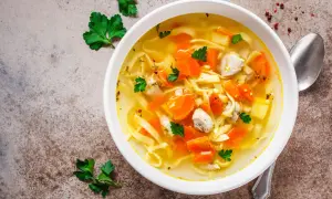 Aromaticzny rosół z indyka z makaronem i marchewką, udekorowany natką pietruszki. Idealny na chłodne dni.