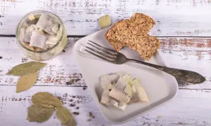 Śledzie z cebulką i chlebem na talerzu. Pytanie, czy w Wielki Piątek można jeść mięso, nie dotyczy tej potrawy.