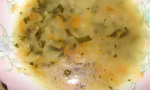 Pyszny rosół z ryżem, z kawałkami marchewki i zielonej natki. Idealny na chłodne dni.