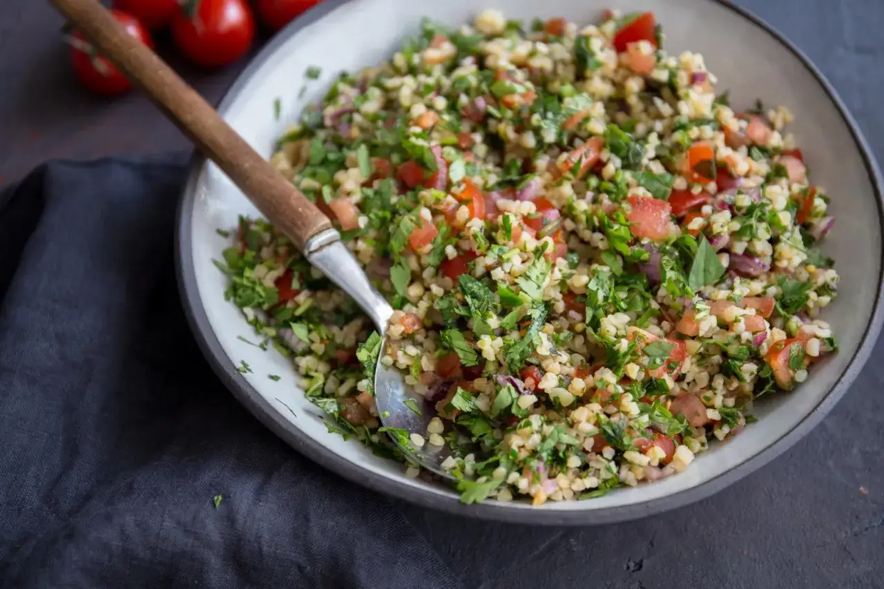 Składniki do tabouleh: drobna kasza bulgur, świeża pietruszka, mięta, pomidory, cytryny