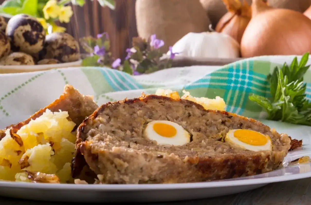 Pyszna pieczeń rzymska Ewy Wachowicz z jajkami przepiórczymi w środku, podana z ziemniakami.